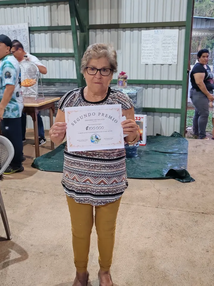 Leticia muestra el certificado del segundo premio de 100 000 colones del Gran Bingo de la ADI Tajo Alto